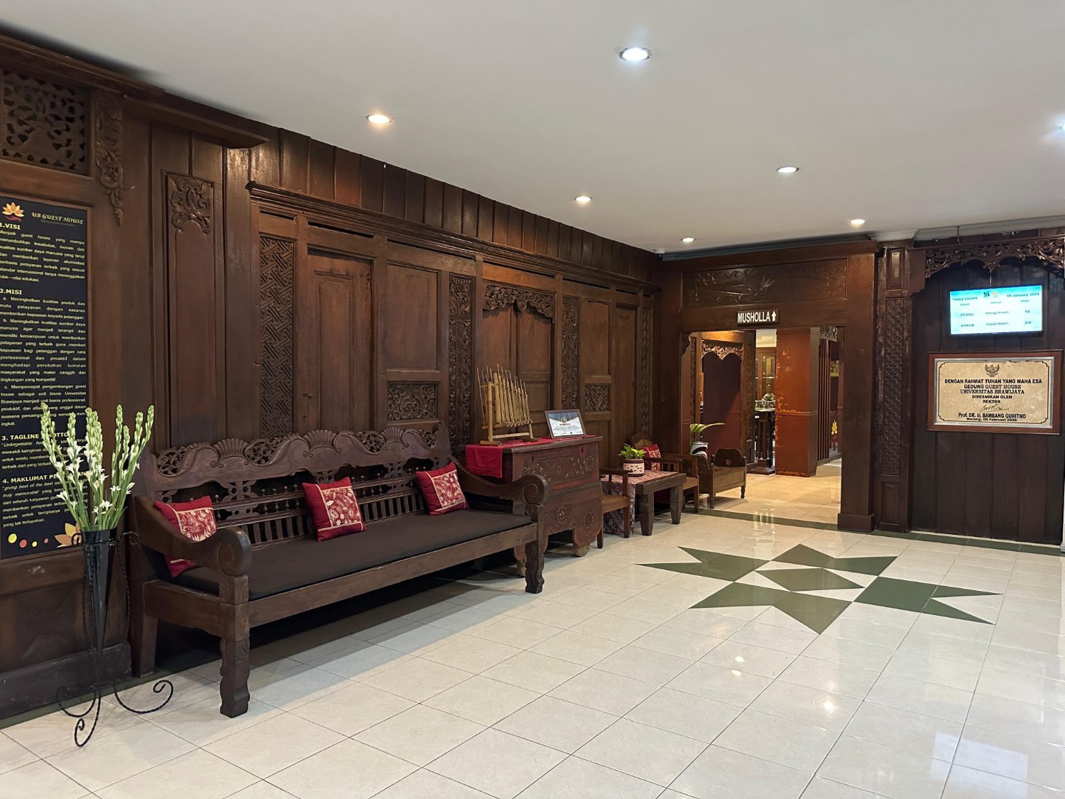 Lobi UB Guest House dengan interior kayu jati ukir khas Jawa dan bantal merah